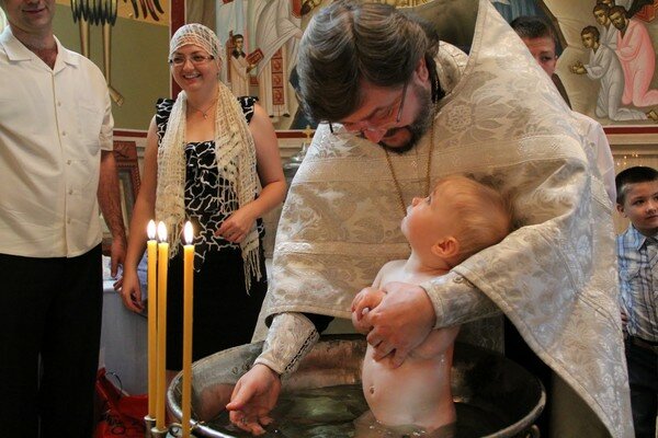 Окунал под крики матери: в РФ священник травмировал малыша во время крещения. Видео