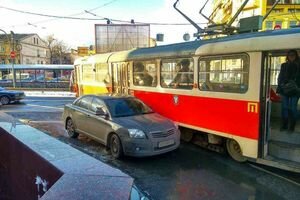 В Киеве пассажиры трамвая самостоятельно сдвинули с рельсов авто "героя парковки" (видео)