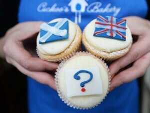 epa04402490 A bakery employee holds a 'question mark' cupcake in front of a Scottish Saltire cake (L) and a Union cupcake (R) at a bakery in Edinburgh, Scotland, 16 September 2014. Polls are showing that the Yes and No camps are neck and neck in the Scottish Independence referendum. Scots will vote wether Scotland should become an independent country 18 September. EPA/ANDY RAIN